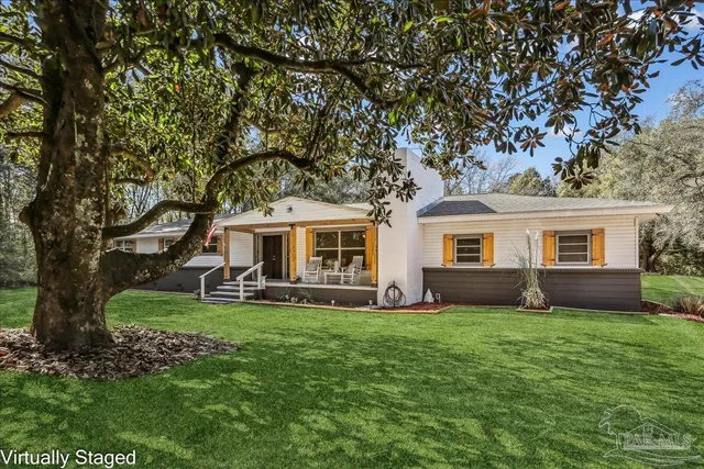 a front view of a house with a yard and trees