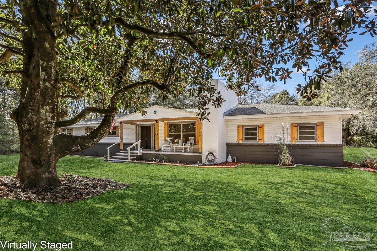 a front view of a house with a yard and trees