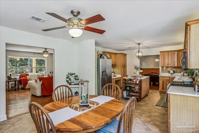 a view of a dining room with furniture a chandelier and a large window