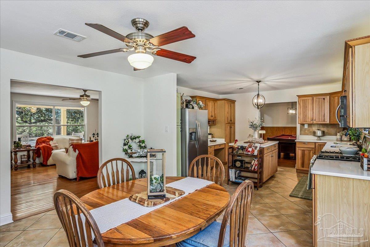 9481 Bridlewood Road Pensacola, FL 32526 - Photo 11 of 45 a view of a dining room with furniture a chandelier and a large window