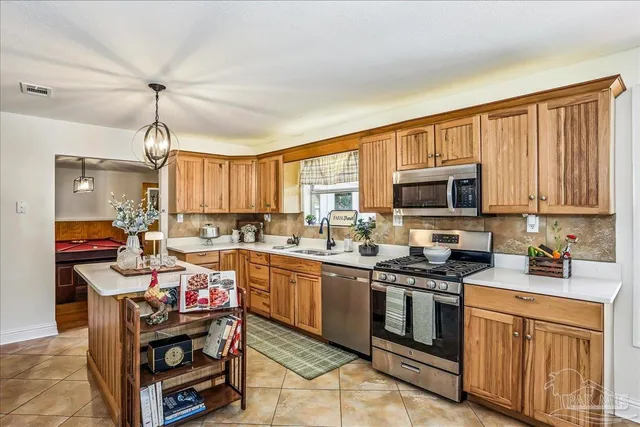 a kitchen with stainless steel appliances a stove sink microwave and cabinets