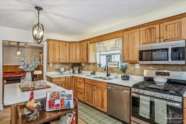 a open kitchen with stainless steel appliances granite countertop a stove and a sink