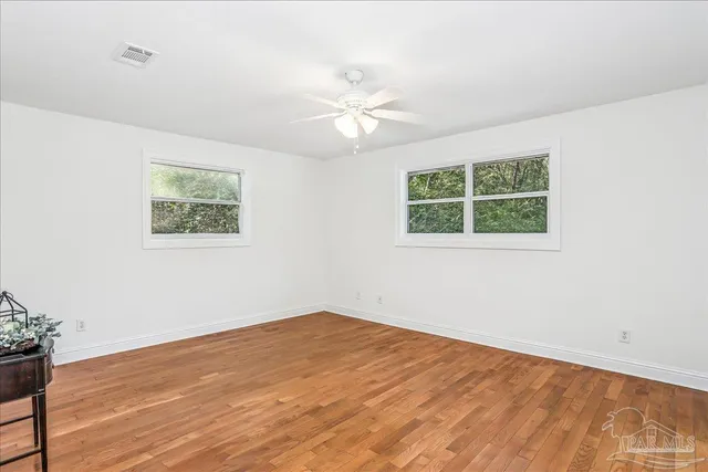 wooden floor in an empty room with a window