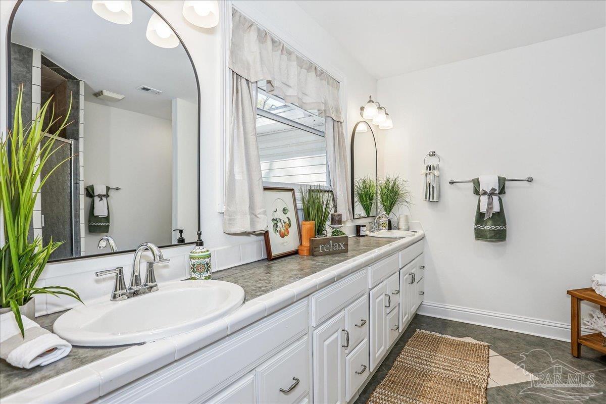 9481 Bridlewood Road Pensacola, FL 32526 - Photo 24 of 45 a bathroom with double vanity sinks a vanity and a large mirror