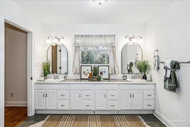 a bathroom with a double vanity sink and a window
