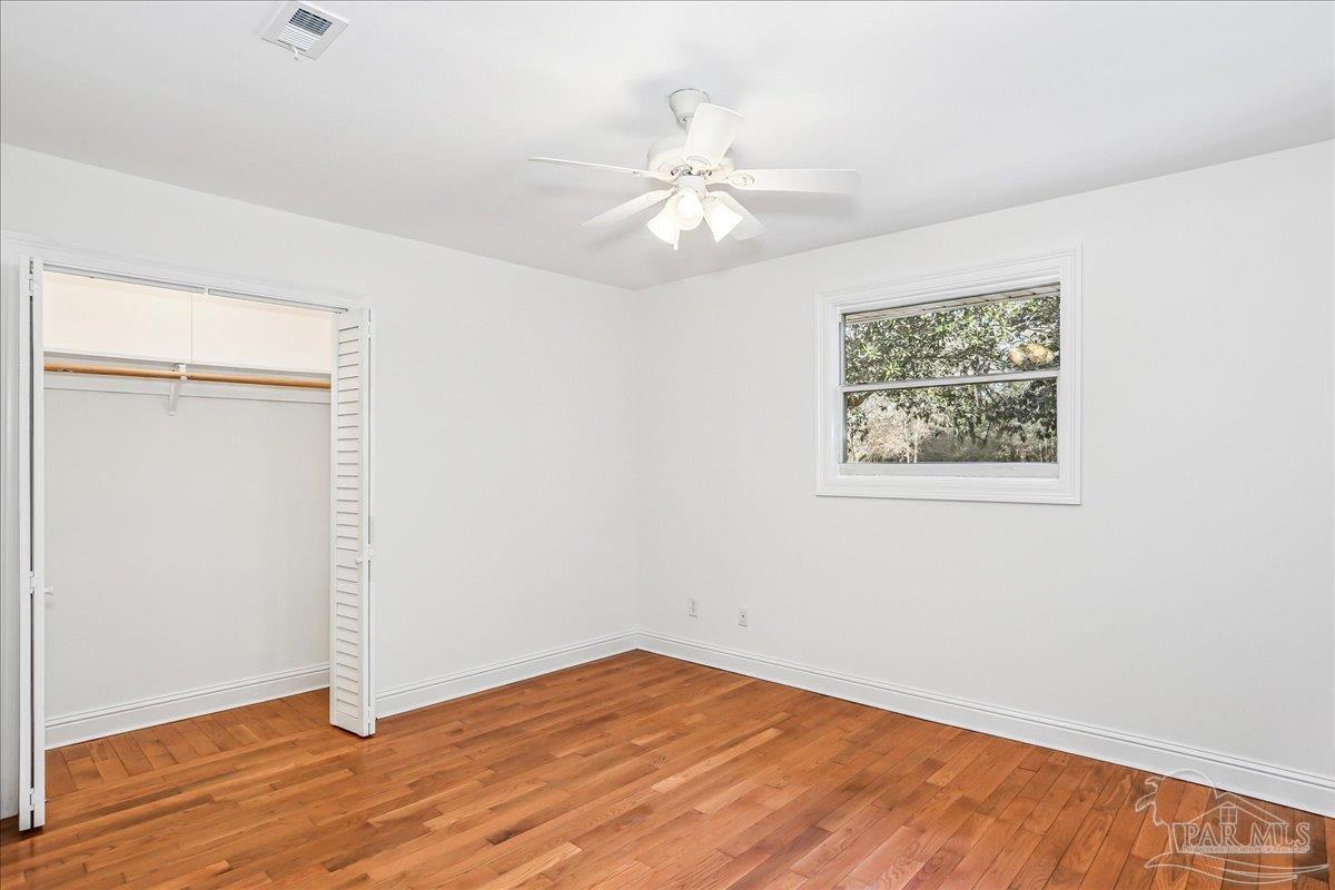 9481 Bridlewood Road Pensacola, FL 32526 - Photo 28 of 45 a view of an empty room with wooden floor and a ceiling fan