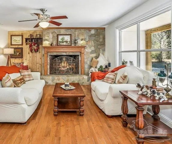 a living room with furniture a fireplace and a large window