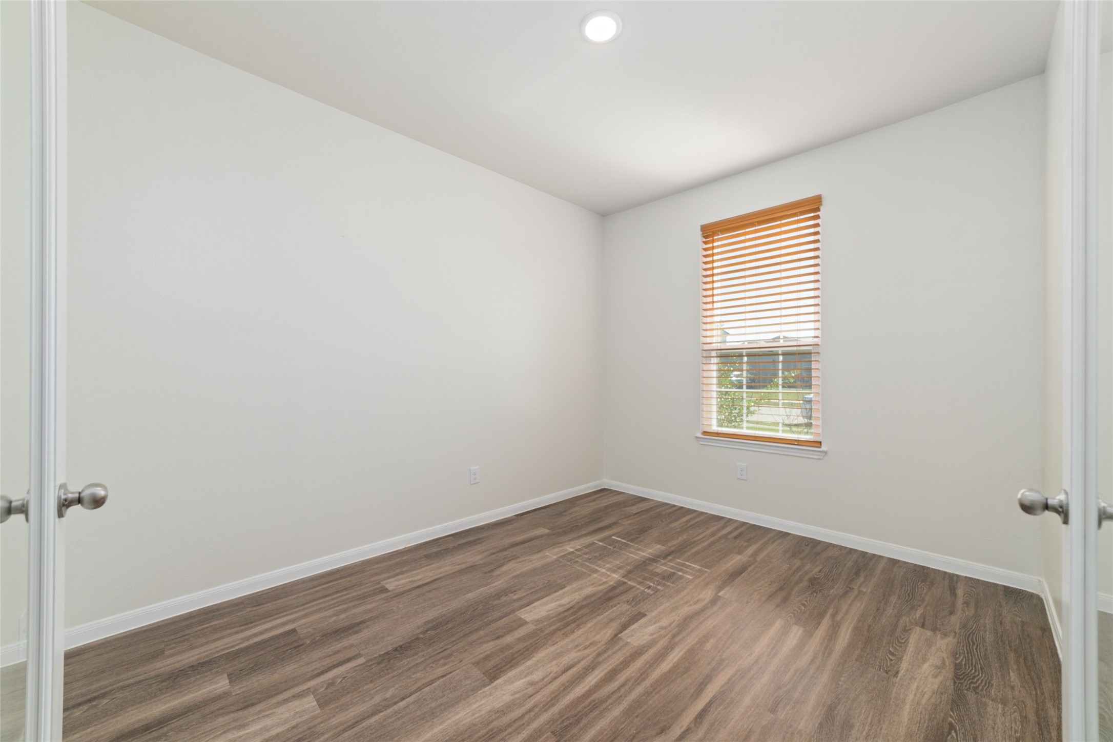 7227 Hobby Wind Ridge Drive Houston, TX 77075 - Photo 11 of 25 an empty room with wooden floor and windows