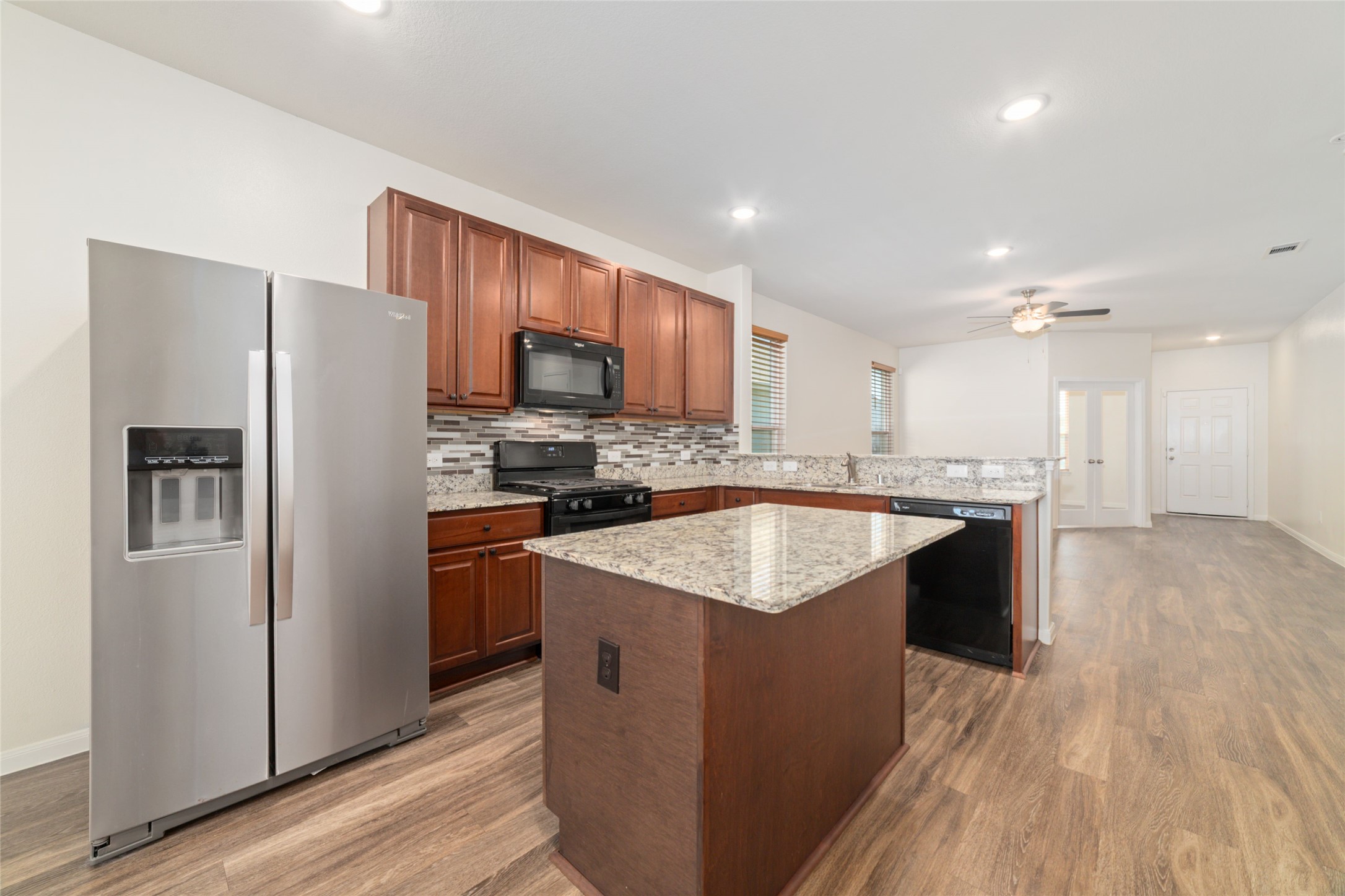 7227 Hobby Wind Ridge Drive Houston, TX 77075 - Photo 14 of 25 a kitchen with stainless steel appliances granite countertop a refrigerator a stove and a wooden floors