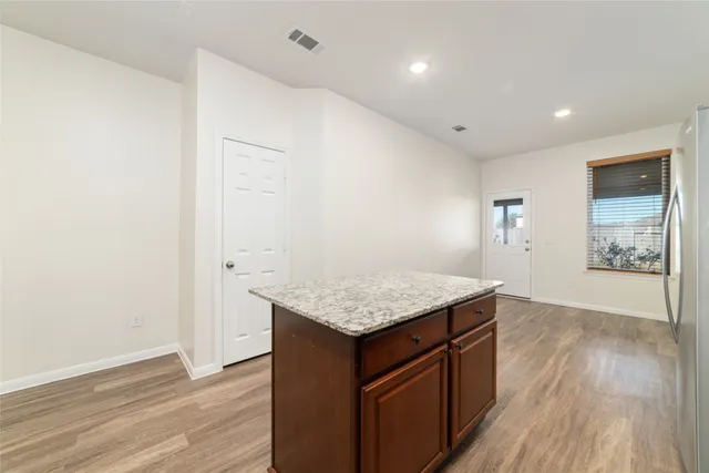 an empty room with wooden floor and window