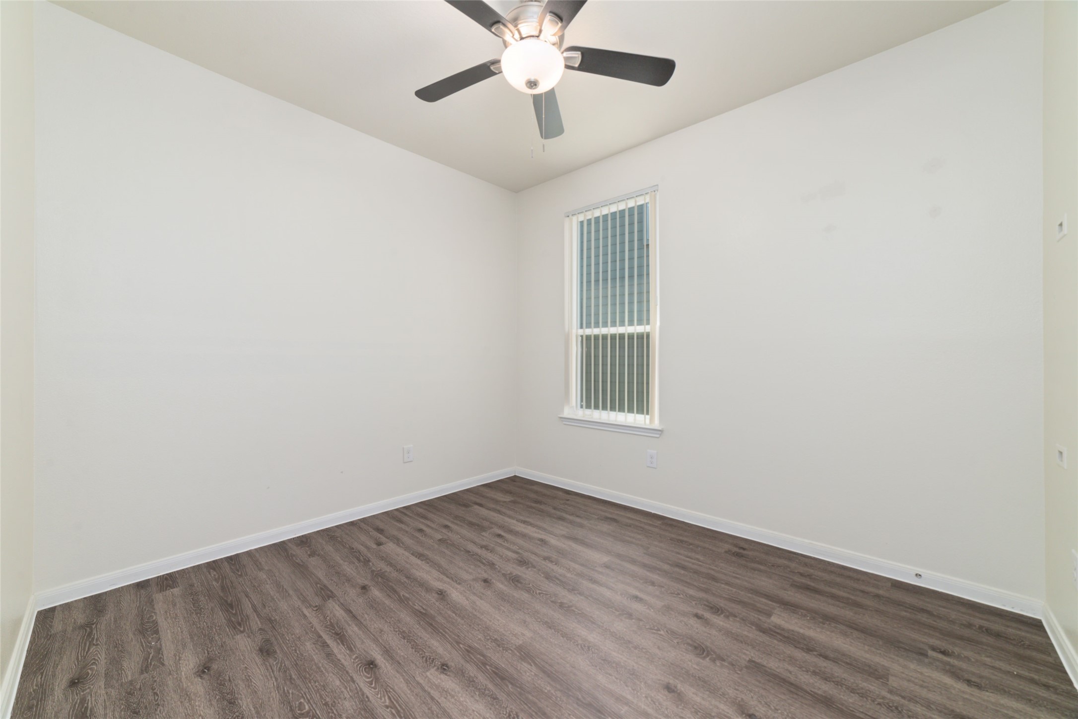 7227 Hobby Wind Ridge Drive Houston, TX 77075 - Photo 21 of 25 an empty room with wooden floor chandelier fan and windows