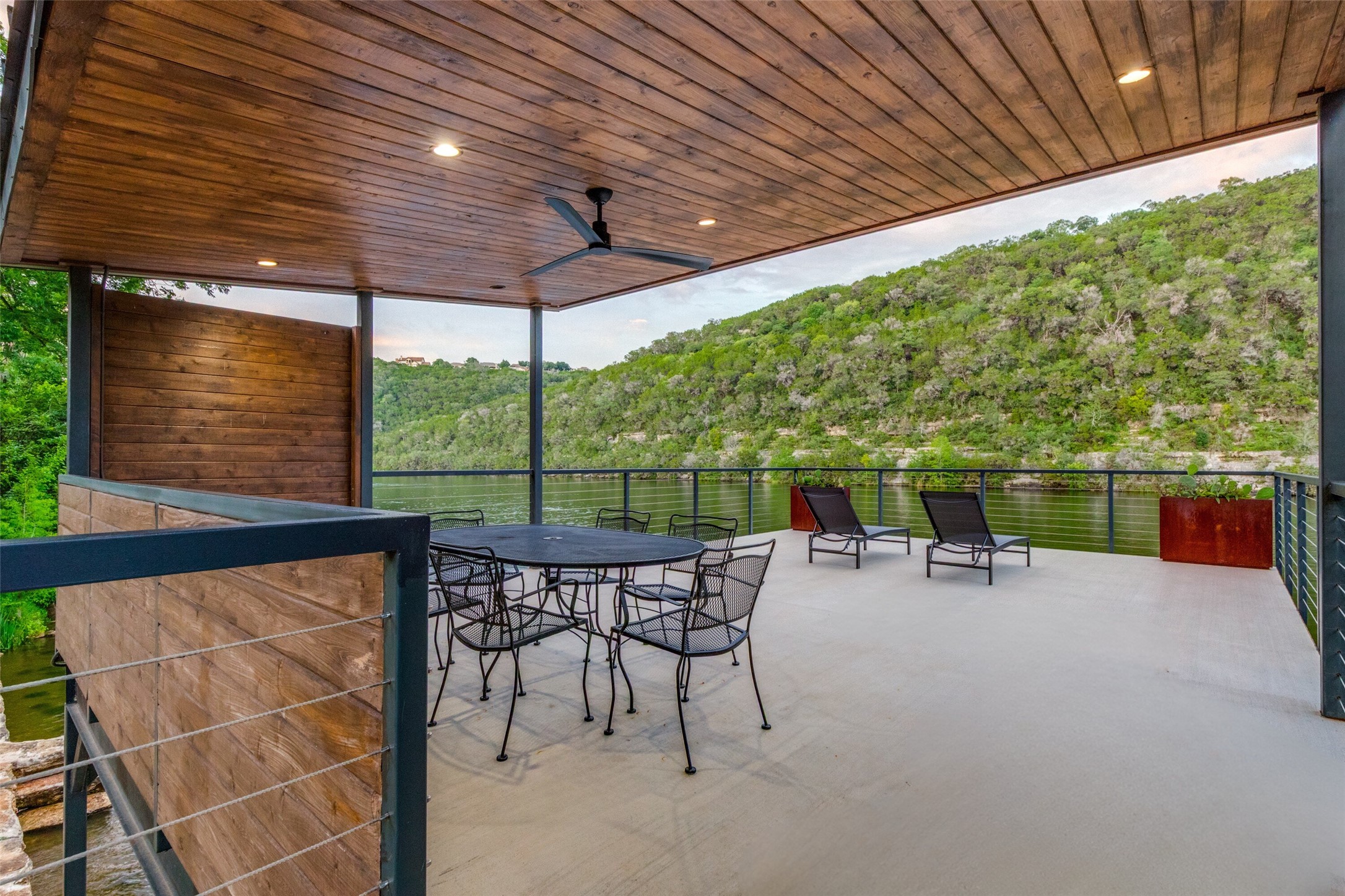 303 Lago Verde Road Austin, TX 78734 - Photo 35 of 39 An inviting deck offers a scenic view of the tranquil water and verdant hillside.