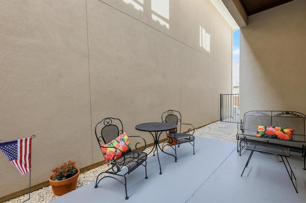 516 Sandy Lane Flower Mound, TX 75022 - Photo 28 of 38 Patio featuring a painted concrete surface, gravel bedding, and a black wrought iron gate