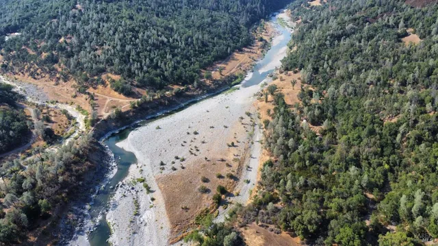 a view of a house with a mountain and a forest