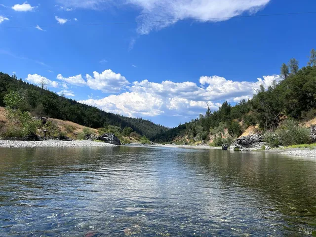 a front view of house with yard and trees in the background
