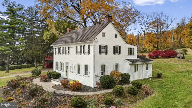 a view of a white house with a yard and plants