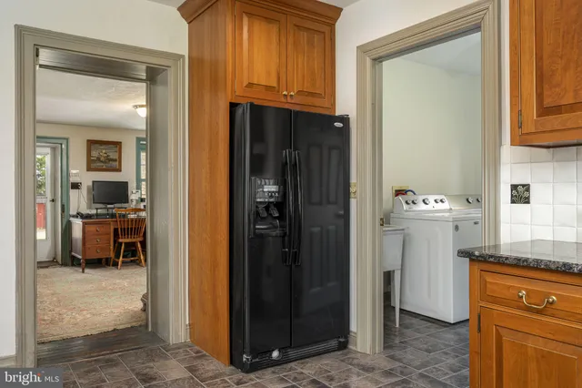 a kitchen with a refrigerator and wooden floor