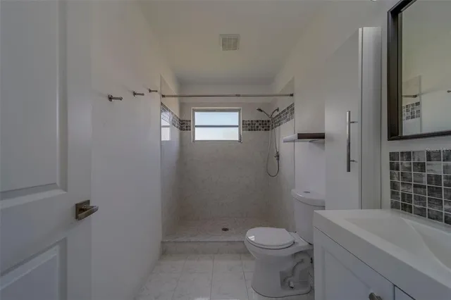 a bathroom with a toilet and a shower