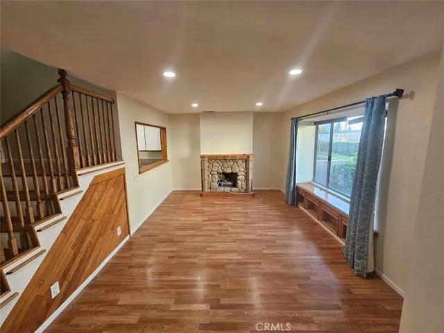 a view of a hallway with wooden floor and a fireplace
