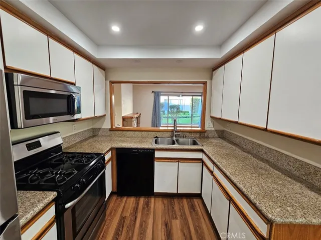 a kitchen with a sink stove top oven and cabinets