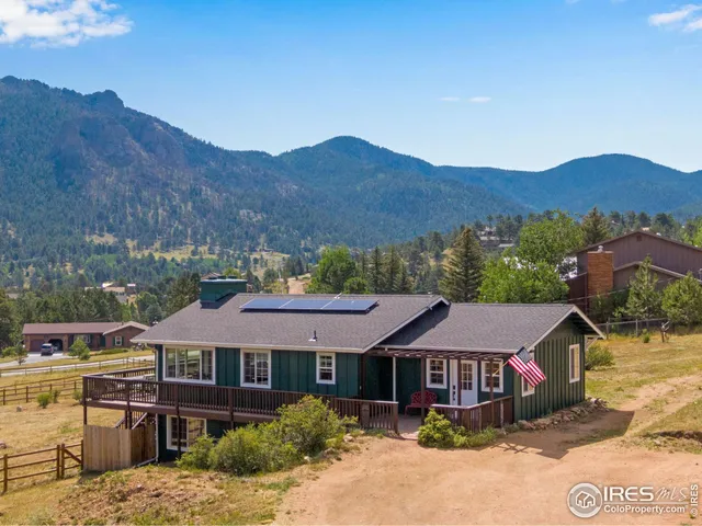 a front view of a house with a yard and mountain