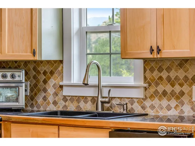 a kitchen with stainless steel appliances kitchen island granite countertop a refrigerator and cabinets