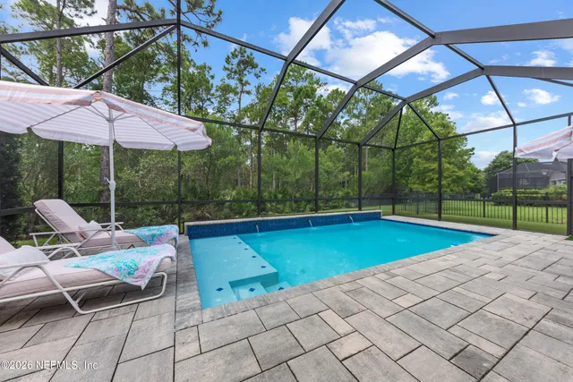 a view of a backyard with swimming pool and sitting area