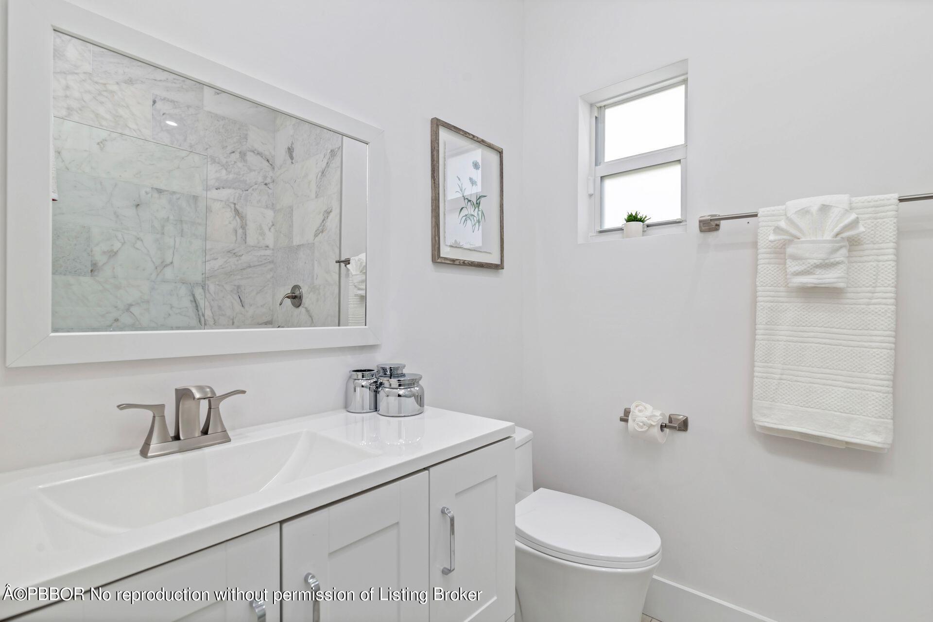 361 Franklin Road West Palm Beach, FL 33405 - Photo 18 of 32 a bathroom with a toilet a sink a mirror and a shower