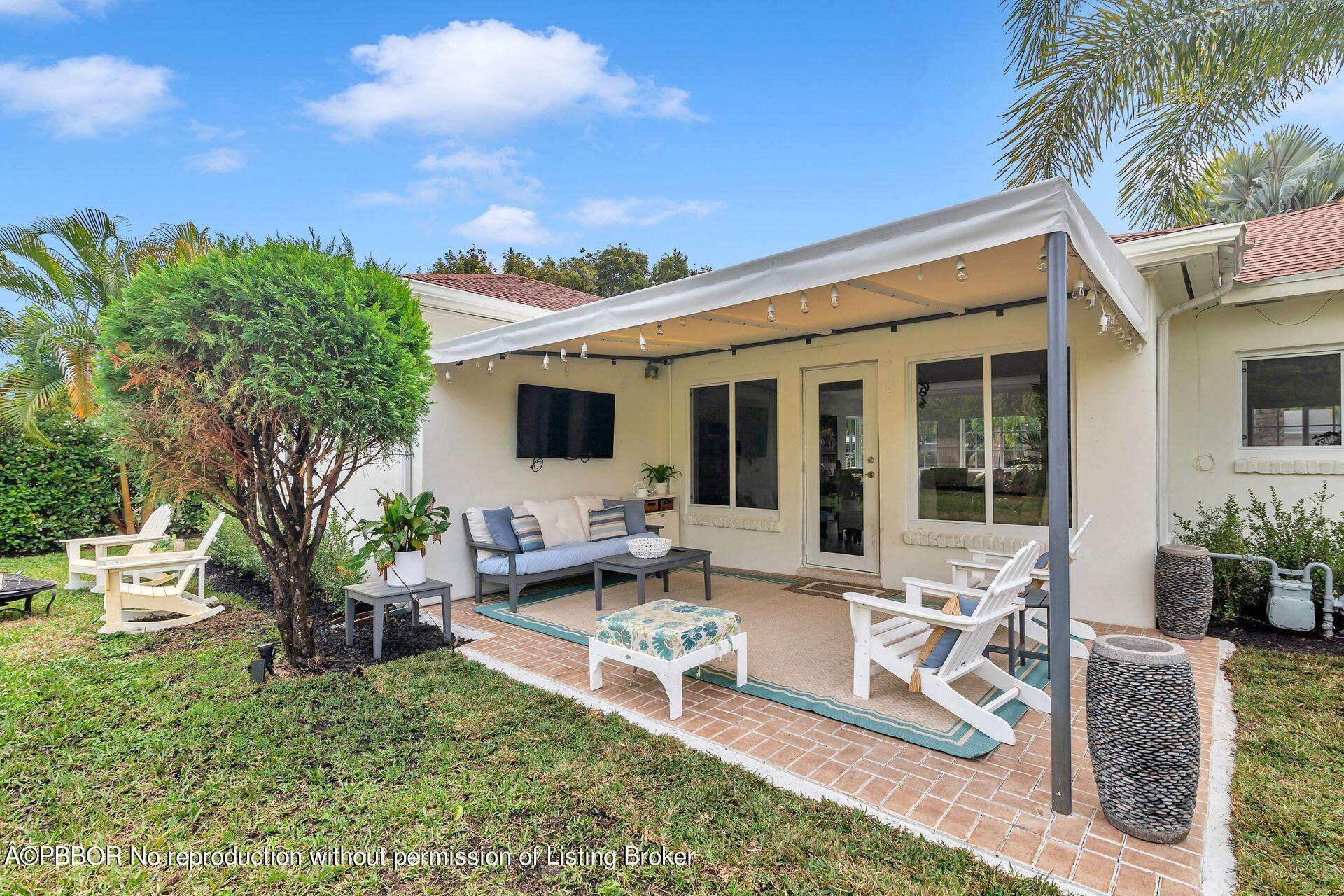 361 Franklin Road West Palm Beach, FL 33405 - Photo 19 of 32 a view of a patio with table and chairs potted plants and palm tree