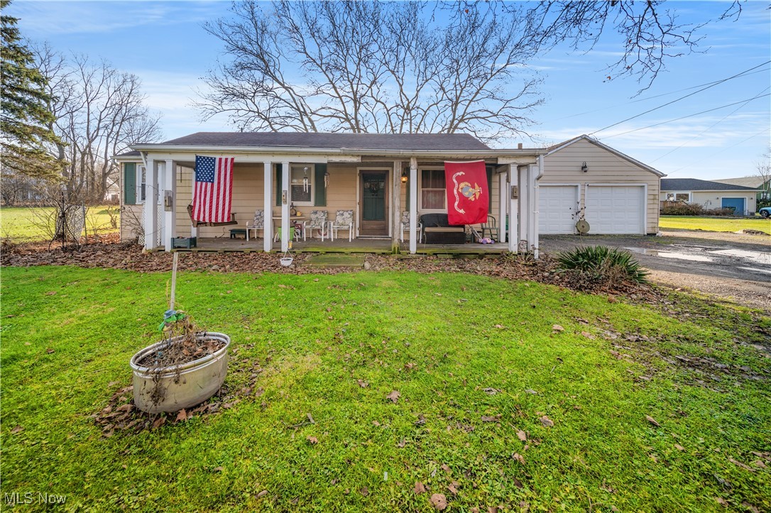 Ranch-style house with a front lawn, covered porch, and a garage