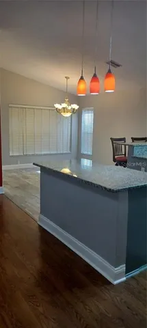 a view of a kitchen with wooden floor and window