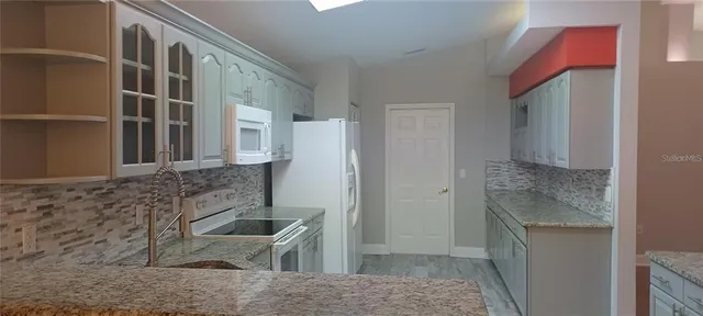 a bathroom with a granite countertop sink and a washing machine