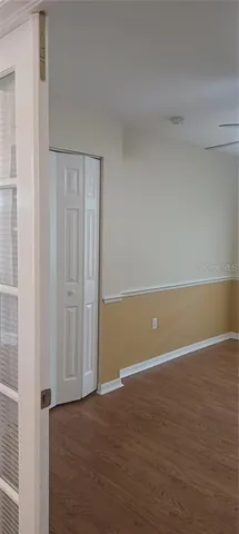 a view of an empty room with wooden floor