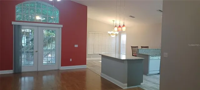 a view of a kitchen with an entryway and chandelier