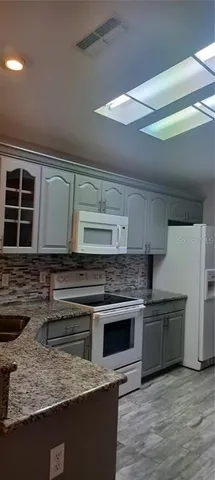 a kitchen with stainless steel appliances granite countertop a stove and a sink