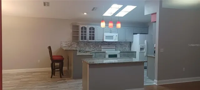 a kitchen with stainless steel appliances granite countertop a sink and a refrigerator