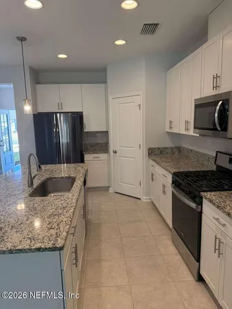 a kitchen with stainless steel appliances granite countertop a refrigerator a stove a sink and a granite counter tops