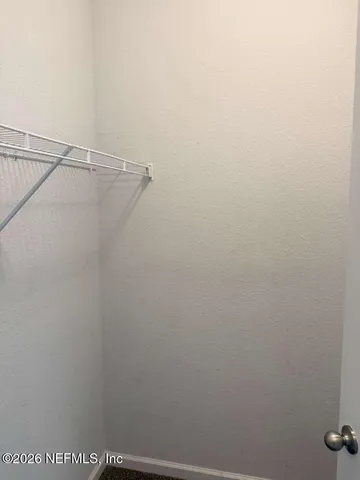 an empty room with a fan and a window