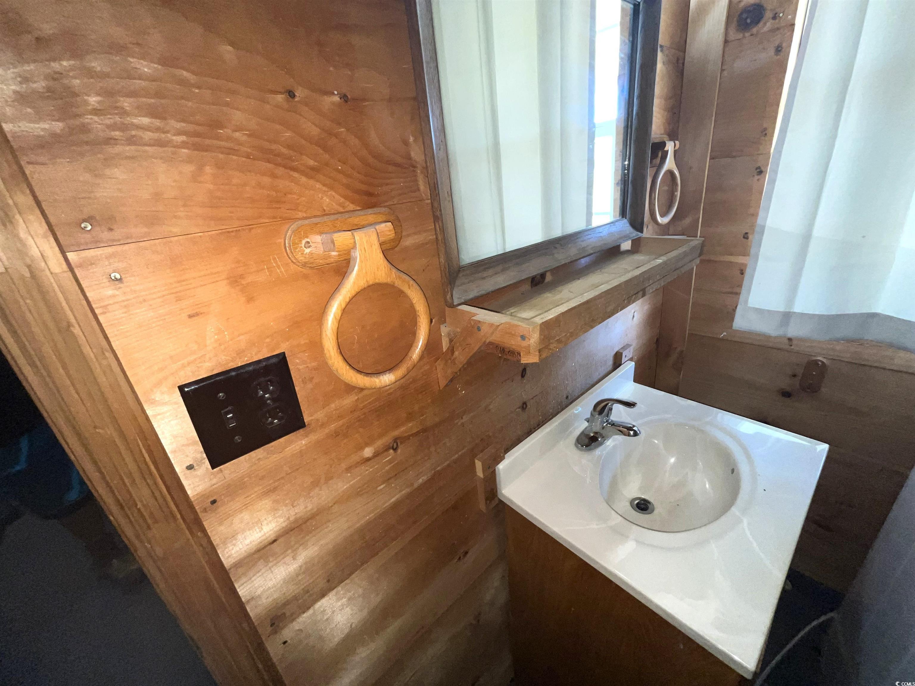 6873 Cribb Road Mullins, SC 29574 - Photo 17 of 28 Bathroom featuring vanity and wooden walls