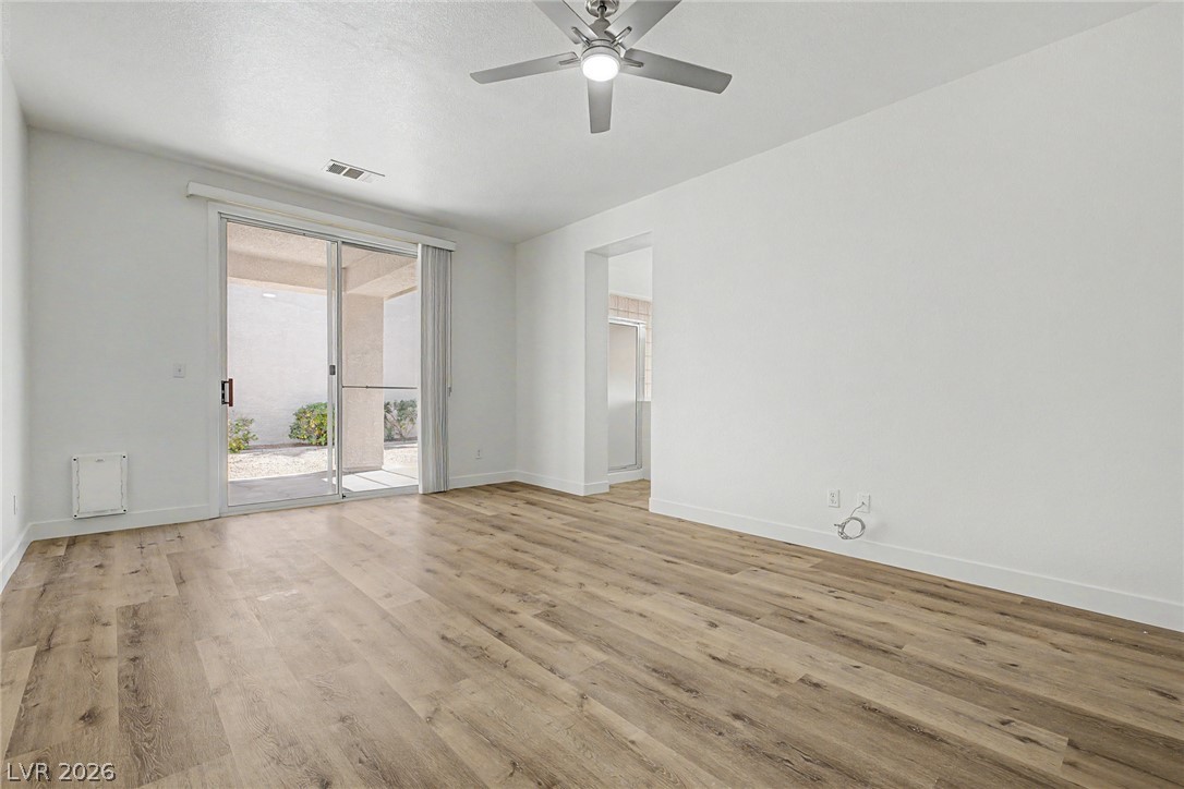 835 Entrada Ridge Avenue Henderson, NV 89012 - Photo 13 of 34 Relax in this well-lit living area featuring rich hardwood floors and seamless patio access.