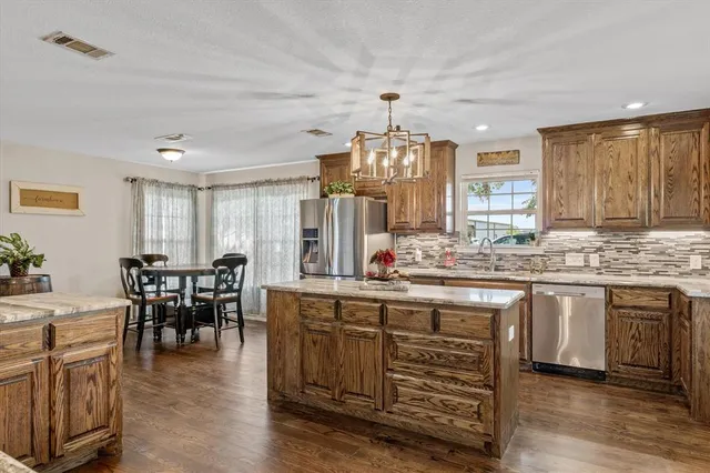 a kitchen with center island table and chairs