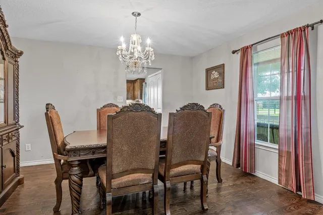 a view of a dining room with furniture a chandelier and window