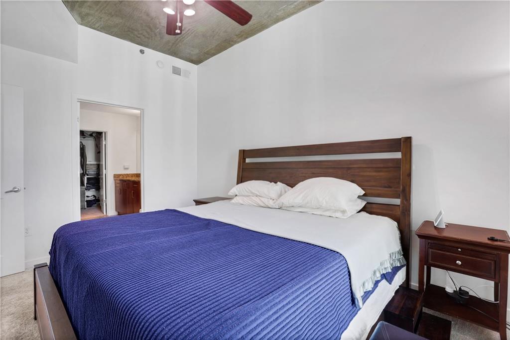250 Pharr Road Northeast, Unit 2005 Atlanta, GA 30305 - Photo 14 of 49 a bedroom with a bed and a lamp on table