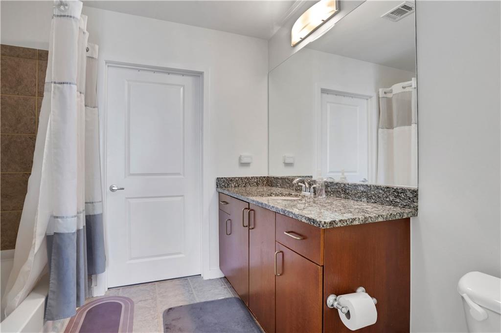 250 Pharr Road Northeast, Unit 2005 Atlanta, GA 30305 - Photo 16 of 49 a bathroom with a granite countertop sink and a mirror