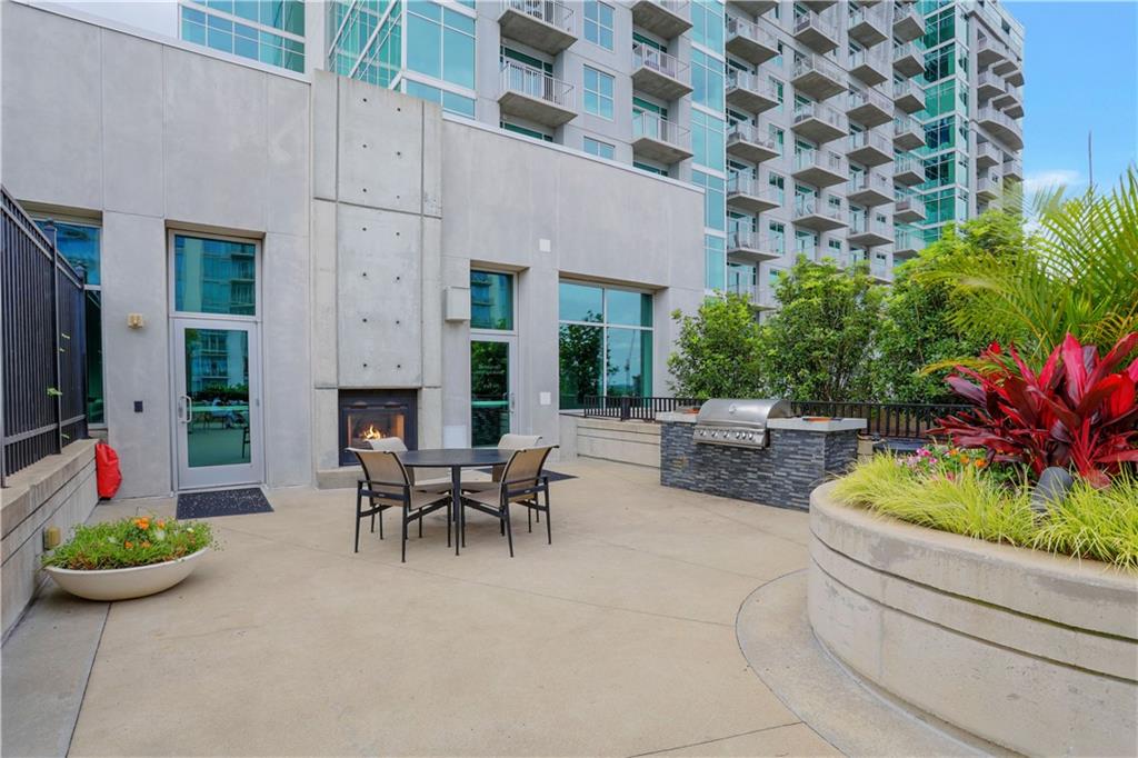 250 Pharr Road Northeast, Unit 2005 Atlanta, GA 30305 - Photo 37 of 49 a view of a patio with couches table and chairs potted plants and palm tree