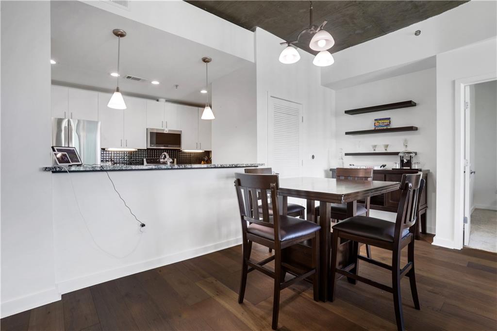 250 Pharr Road Northeast, Unit 2005 Atlanta, GA 30305 - Photo 6 of 49 a kitchen with a dining table chairs stainless steel appliances and cabinets