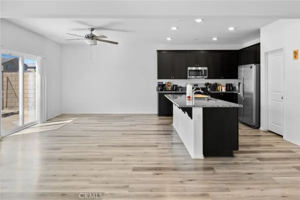 a kitchen with stainless steel appliances kitchen island granite countertop a refrigerator and a stove top oven