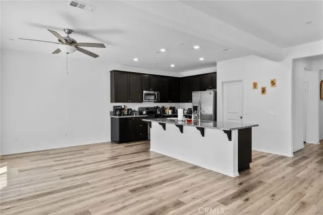 a kitchen with stainless steel appliances granite countertop a refrigerator a stove top oven a sink and dishwasher