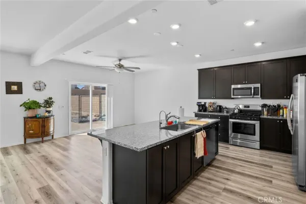 a kitchen with stainless steel appliances granite countertop a refrigerator a sink and a stove