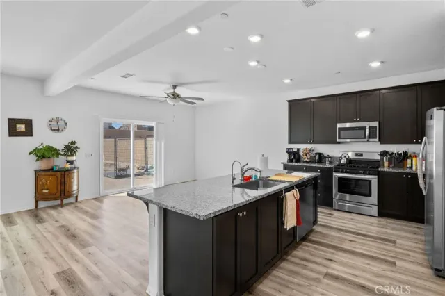 a kitchen with stainless steel appliances granite countertop a refrigerator a sink and a stove